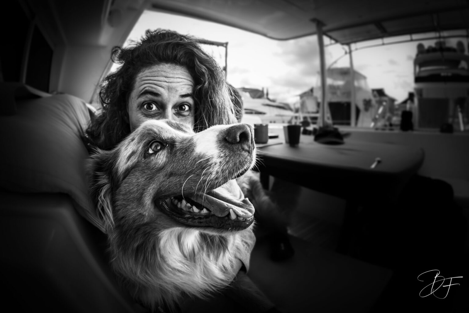 Black and white portrait of a crew member and the ship’s dog in the saloon